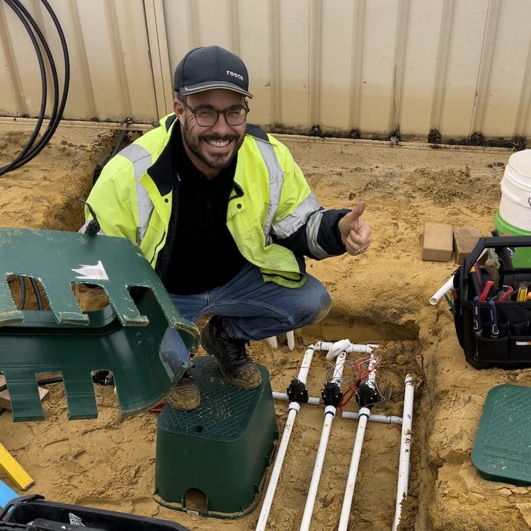 Luke wearing hi-vis repairing a broken pipe